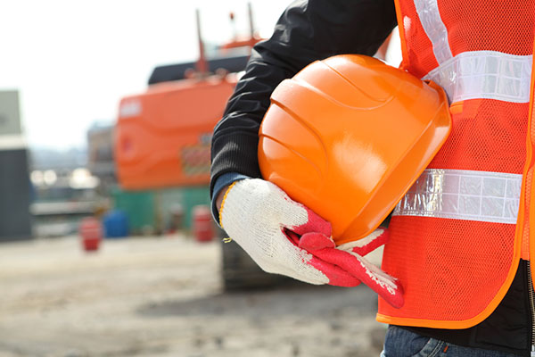 Man holding hard hat on construction site