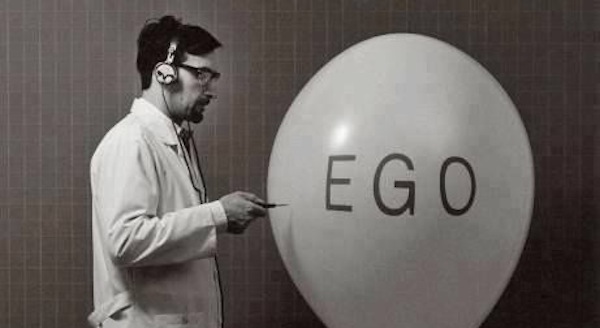 Man popping balloon with "ego" written on it