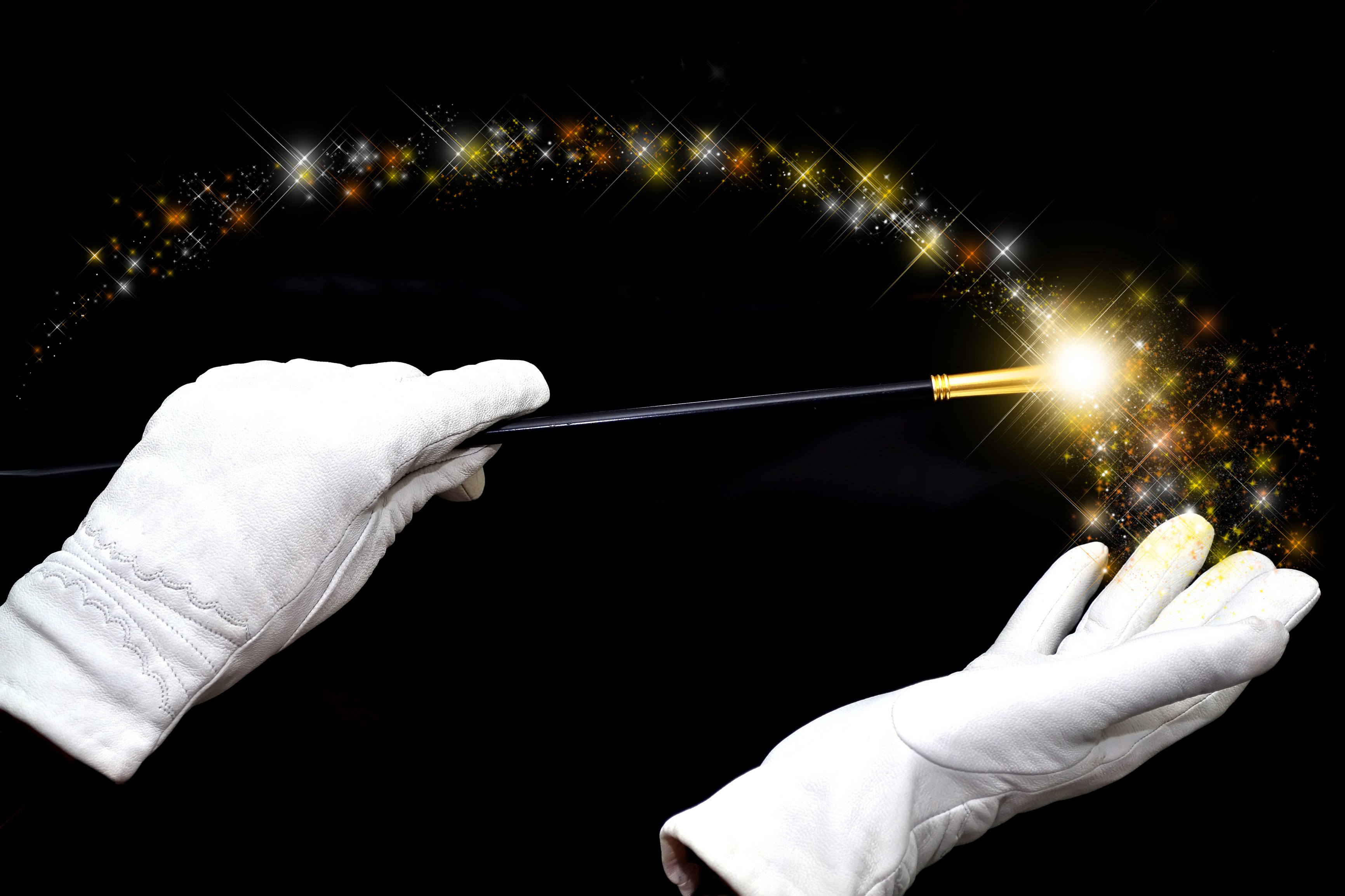 White gloved hands holding a magic wand